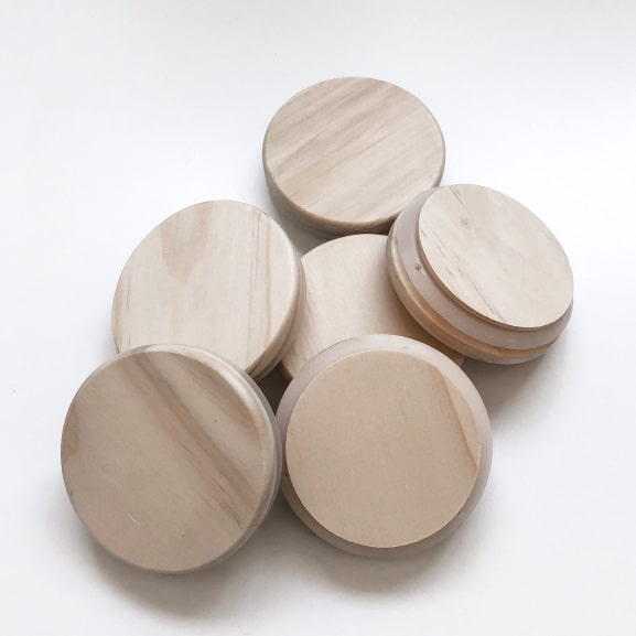 Biodegradable beige wooden lids on a white background.